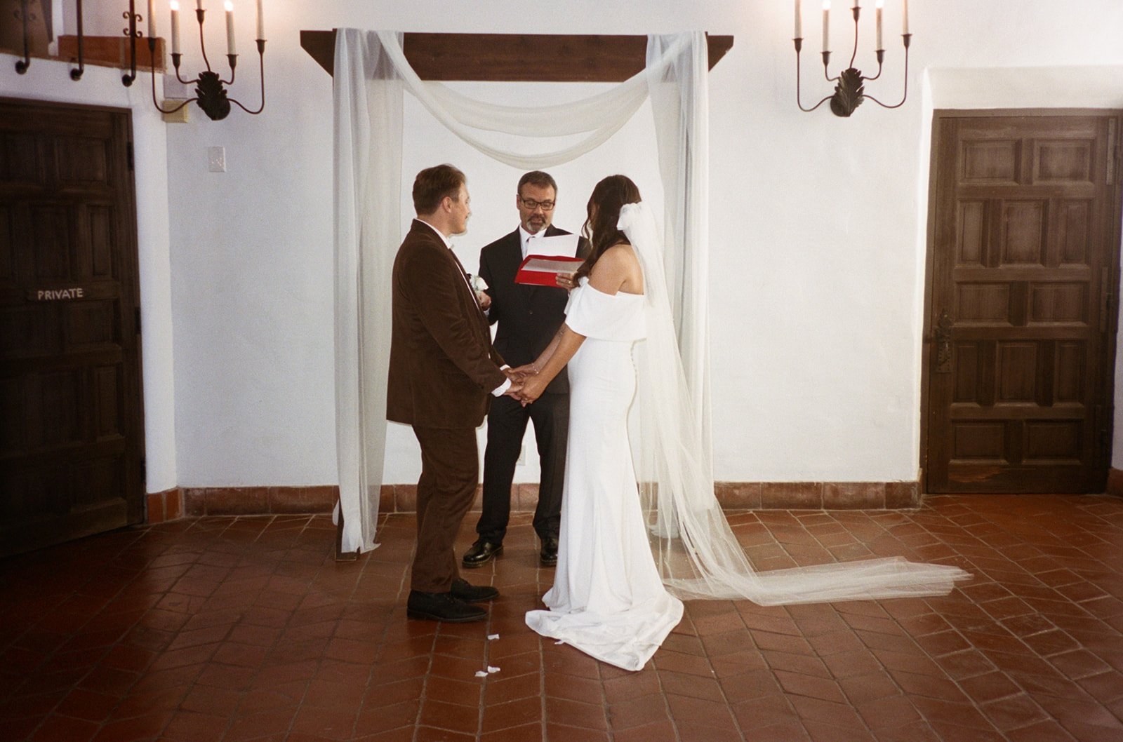 An indoor San Diego wedding ceremony on film at The Juniper Serra Museum